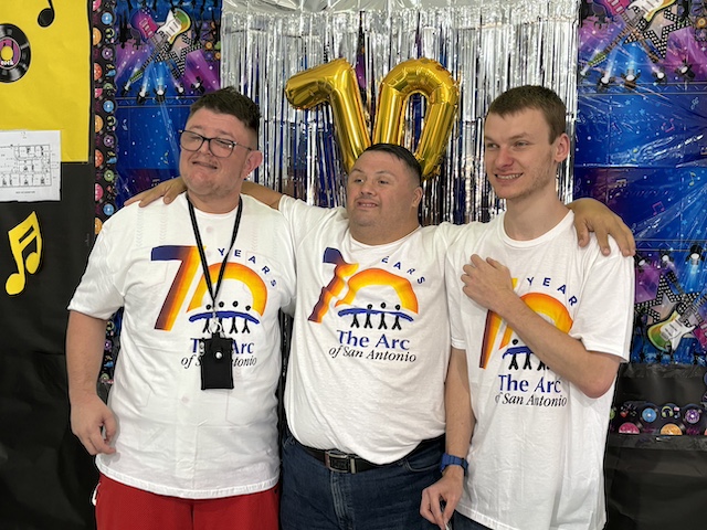 Three individuals enjoying a celebration at a day habilitation center.