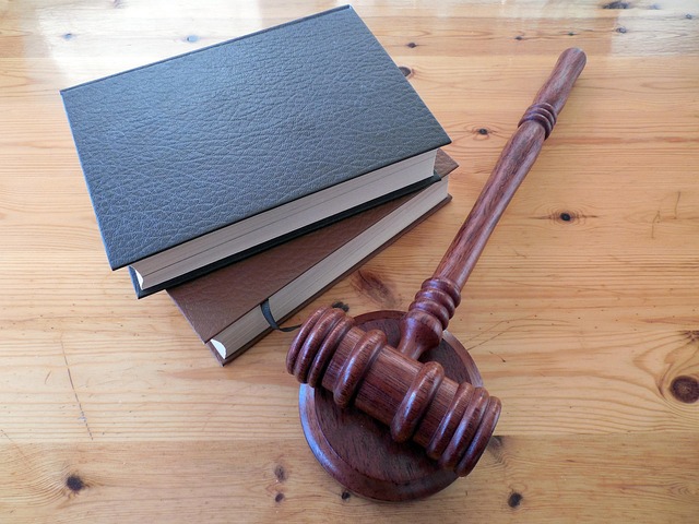 A gavel on a table next to two law books